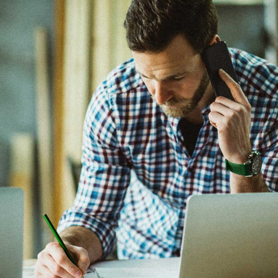 man on the phone and taking down notes