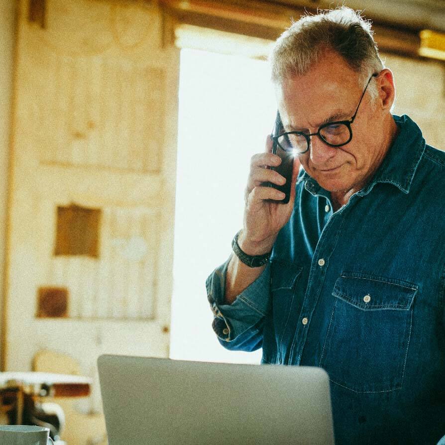 man on the phone and using laptop