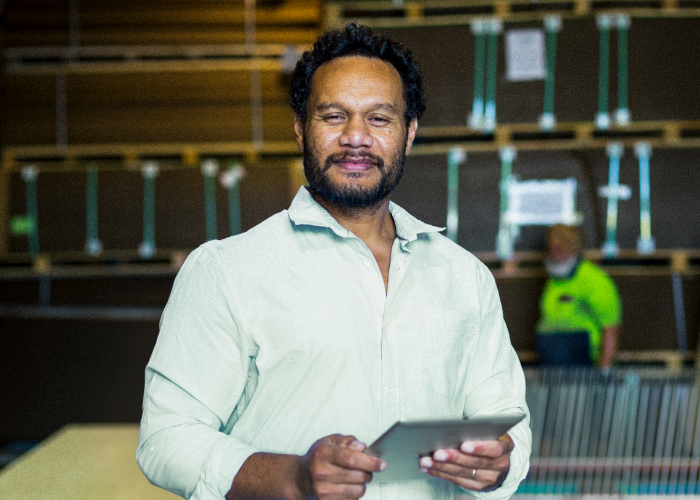 man in construction warehouse holding a tablet