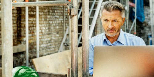 man in construction site using laptop