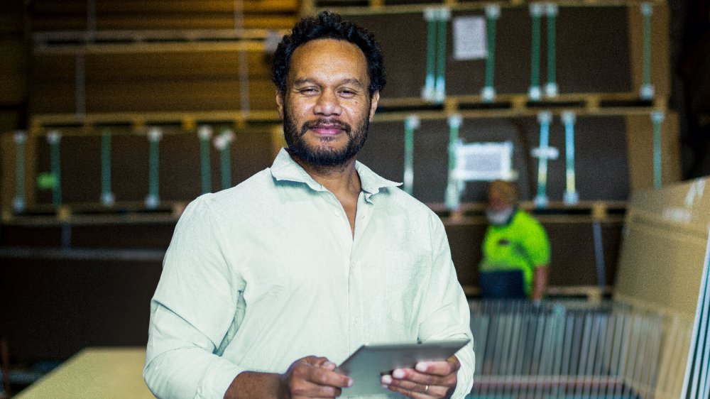 man in construction warehouse holding a tablet